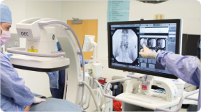 Medical personnel using a scanner, the output is displayed on a monitor.